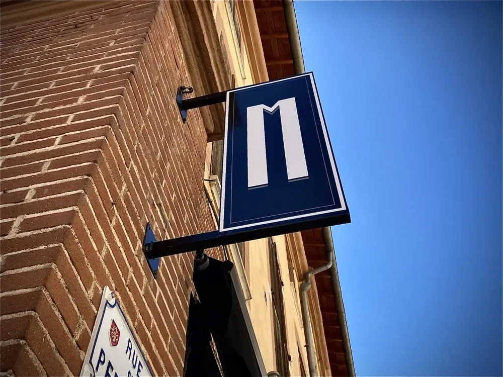 Enseigne drapeau sur façade en brique