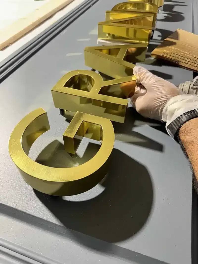 Finition à la main de lettres dorées dans l'atelier
