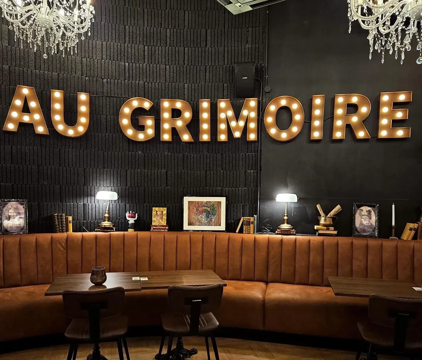 Lettres ampoules Au Grimoire au-dessus de la banquette d’un restaurant